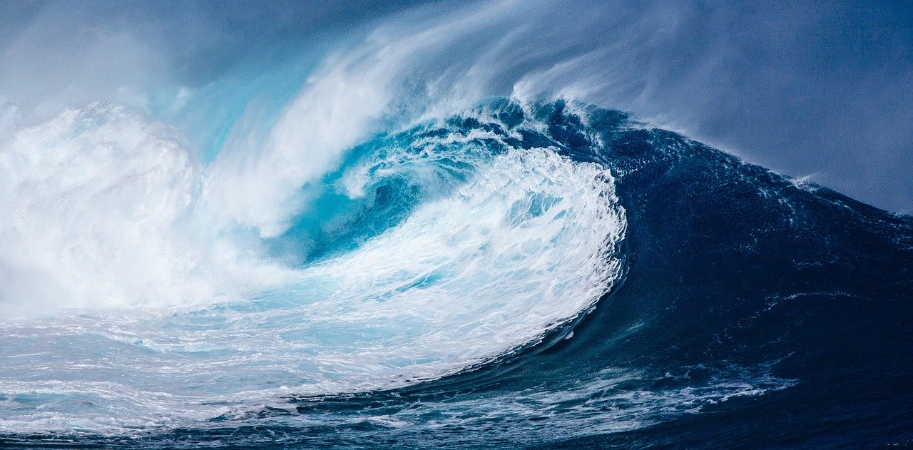 白いしぶきを上げて崩れる青い海の波
