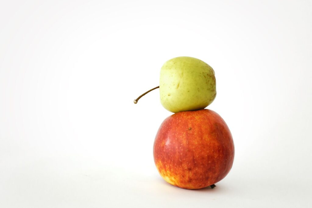 A clean and creative studio shot of two stacked apples, showcasing fresh fruit in a minimalist style.