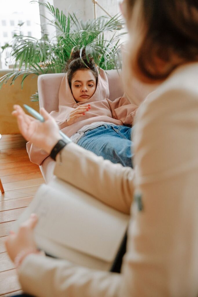 A teenager receiving counseling on a sofa with a therapist, creating a warm and supportive atmosphere.